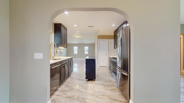 601 SE Karrigan Ter, Port Saint Lucie, FL 34983 - kitchen with appliances with stainless steel finishes, arched walkways, light countertops, light marble finish floors, and recessed lighting