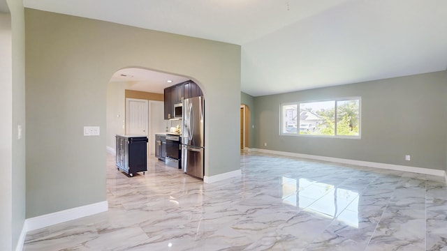 601 SE Karrigan Ter, Port Saint Lucie, FL 34983 - spare room featuring arched walkways, light marble finish flooring, and vaulted ceiling