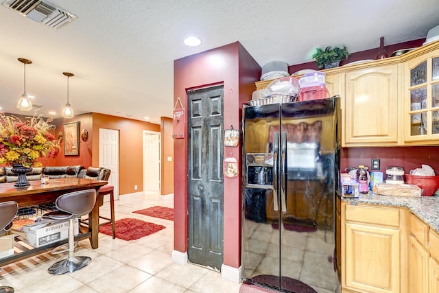 kitchen featuring pendant lighting, light tile patterned floors, a textured ceiling, light brown cabinetry, and black refrigerator with ice dispenser