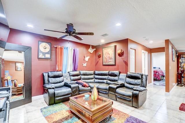 living room with ceiling fan and a textured ceiling