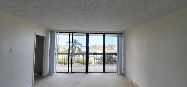 2425 Presidential Way Unit 402, West Palm Beach, FL 33401 - unfurnished room with light carpet, a wall of windows, a textured ceiling, and baseboards