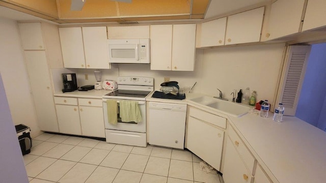 kitchen featuring white cabinets, light tile patterned flooring, white appliances, and sink