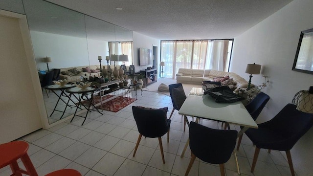 dining space with expansive windows, light tile patterned floors, and a textured ceiling