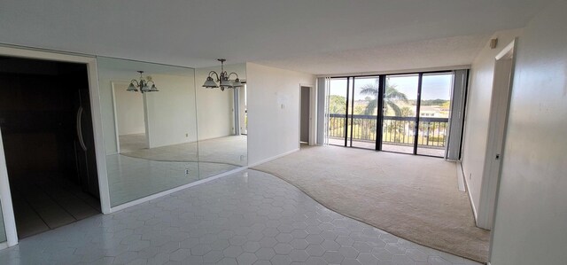 2425 Presidential Way Unit 402, West Palm Beach, FL 33401 - unfurnished bedroom featuring a chandelier, carpet flooring, floor to ceiling windows, access to outside, and baseboards