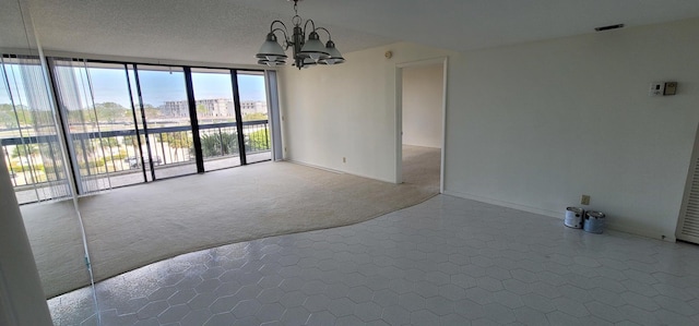 2425 Presidential Way Unit 402, West Palm Beach, FL 33401 - empty room featuring carpet flooring, a chandelier, a wall of windows, baseboards, and a textured ceiling