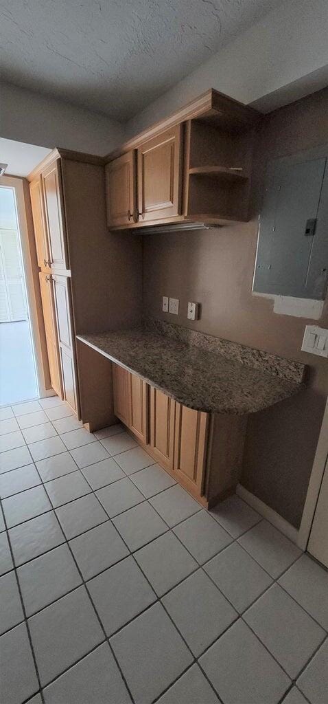2425 Presidential Way Unit 402, West Palm Beach, FL 33401 - kitchen featuring electric panel, light tile patterned flooring, a textured ceiling, and open shelves