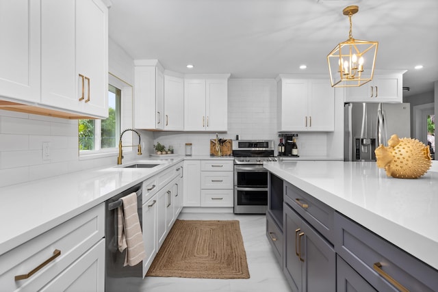 kitchen with white cabinetry, backsplash, hanging light fixtures, gray cabinets, and appliances with stainless steel finishes