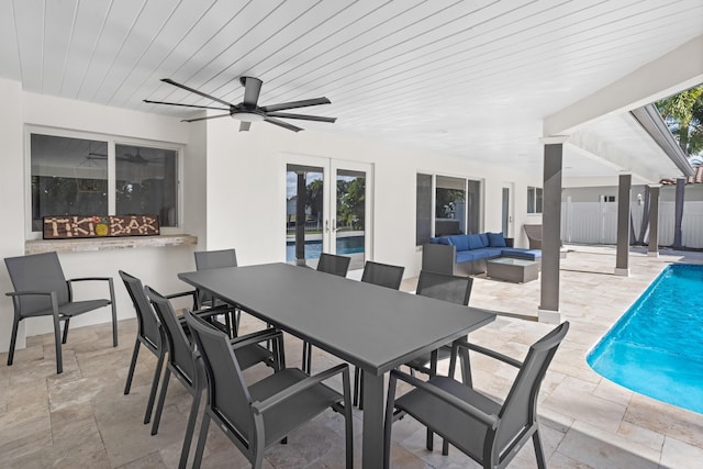 view of patio / terrace with ceiling fan, an outdoor living space with a fireplace, and a fenced in pool