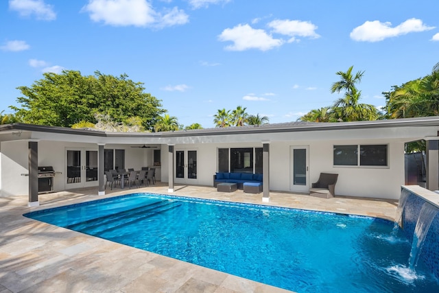 view of pool with french doors, ceiling fan, pool water feature, outdoor lounge area, and a patio area