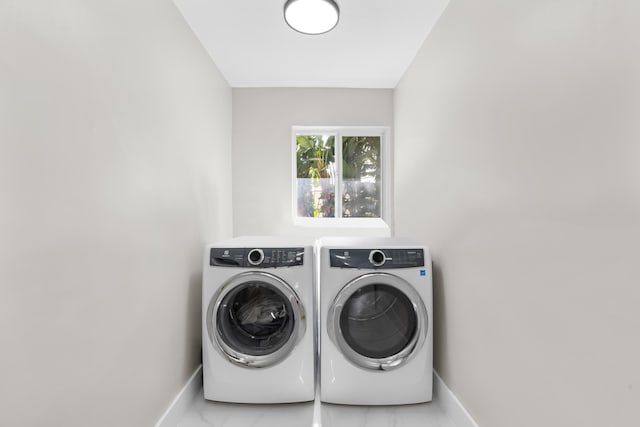 clothes washing area with washer and clothes dryer