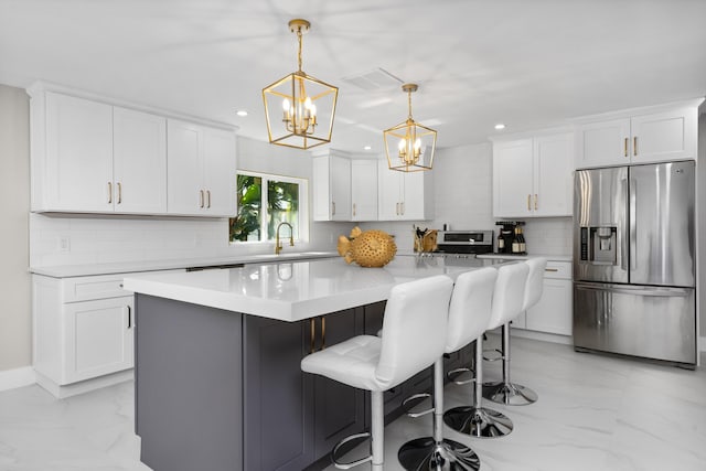 kitchen featuring stainless steel refrigerator with ice dispenser, decorative light fixtures, a center island, and white cabinets