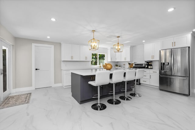 kitchen featuring a kitchen island, white cabinetry, hanging light fixtures, and stainless steel fridge with ice dispenser