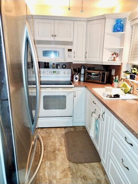 kitchen with white appliances, sink, and white cabinetry