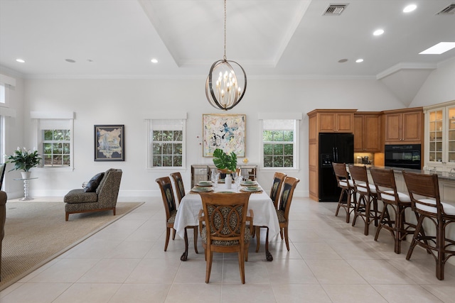 tiled dining room featuring crown molding, plenty of natural light, and a notable chandelier