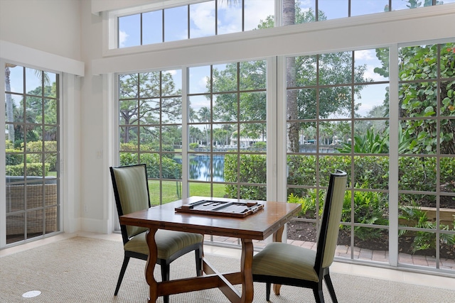 sunroom featuring a water view