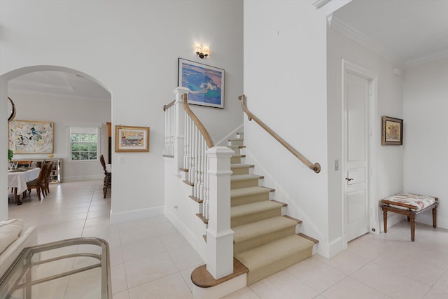 stairs with tile patterned floors and ornamental molding