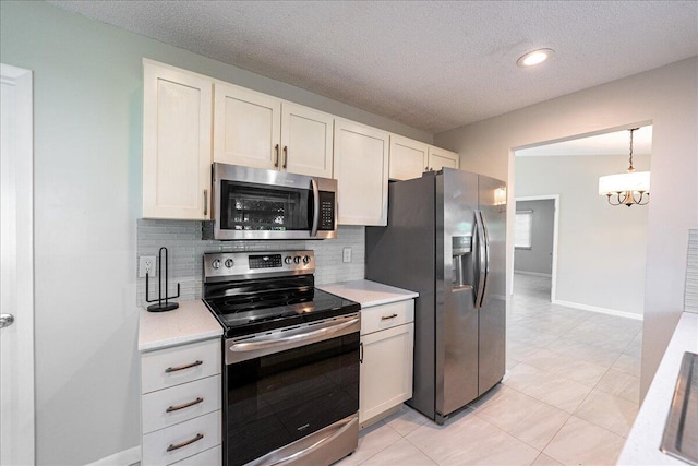 kitchen featuring stainless steel appliances, light tile patterned floors, white cabinets, decorative light fixtures, and tasteful backsplash