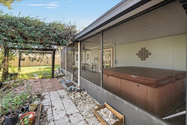 view of patio with a hot tub and a sunroom