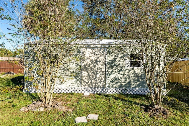 view of side of property with a yard and a storage shed