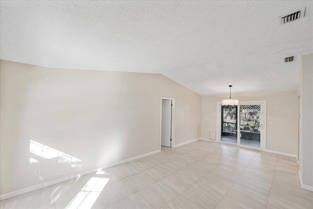 tiled spare room featuring lofted ceiling and a chandelier