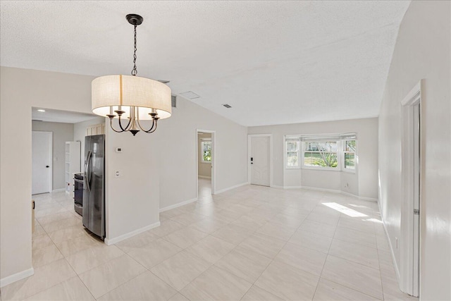 unfurnished room with a textured ceiling, an inviting chandelier, lofted ceiling, and light tile patterned floors