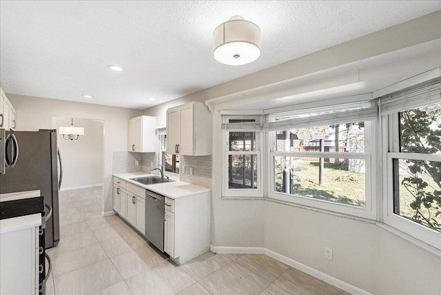 kitchen featuring sink, stainless steel dishwasher, decorative backsplash, and white cabinetry