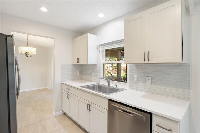 kitchen with hanging light fixtures, tasteful backsplash, white cabinets, appliances with stainless steel finishes, and sink