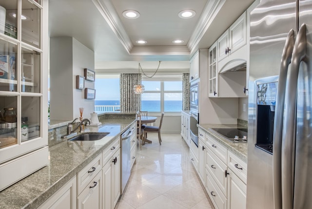 kitchen with sink, stainless steel appliances, white cabinets, and a water view