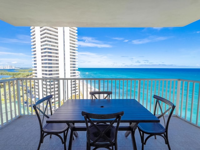 balcony featuring a beach view and a water view