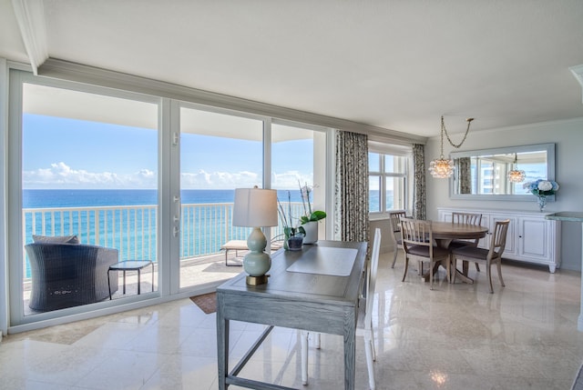 dining room with ornamental molding, a notable chandelier, and a water view