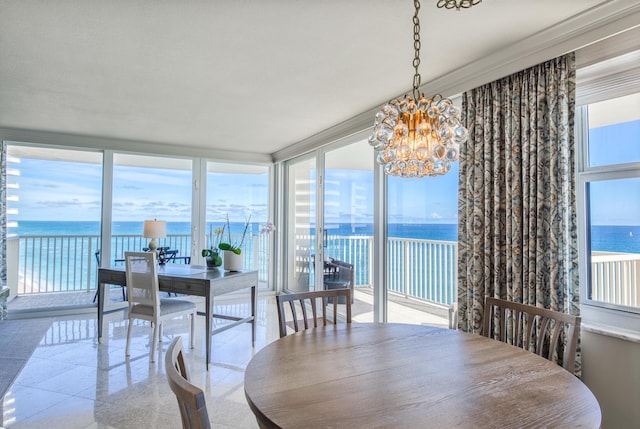 dining area featuring expansive windows, a notable chandelier, a wealth of natural light, and a water view