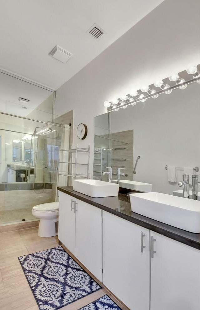 bathroom with toilet, an enclosed shower, and vanity