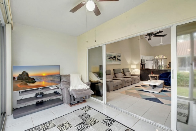 living room with ceiling fan, light tile patterned flooring, and vaulted ceiling