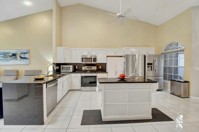 kitchen with sink, high vaulted ceiling, white cabinets, and appliances with stainless steel finishes