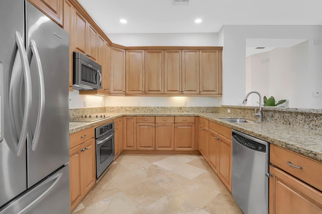 kitchen featuring light stone countertops, sink, and appliances with stainless steel finishes