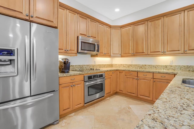 kitchen with sink, stainless steel appliances, and light stone counters