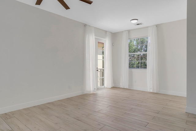 empty room with ceiling fan and light hardwood / wood-style flooring