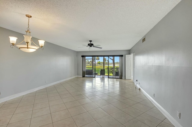 spare room featuring ceiling fan with notable chandelier, a textured ceiling, and light tile patterned floors