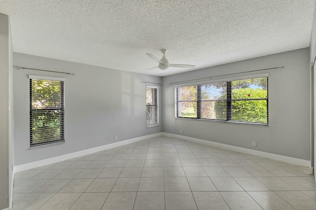 spare room with a textured ceiling, ceiling fan, and light tile patterned floors