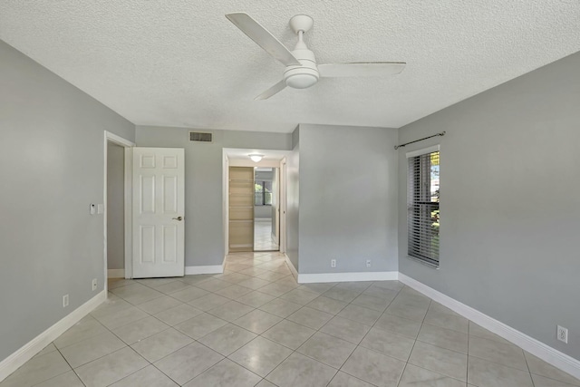 tiled empty room with a textured ceiling and ceiling fan