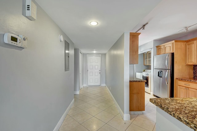 corridor featuring washing machine and dryer and light tile patterned floors