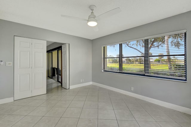 empty room featuring ceiling fan and light tile patterned floors