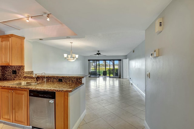 kitchen featuring light tile patterned floors, sink, stainless steel dishwasher, backsplash, and ceiling fan with notable chandelier