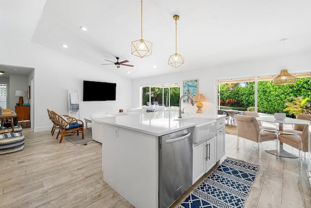 kitchen with lofted ceiling, decorative light fixtures, dishwasher, and an island with sink