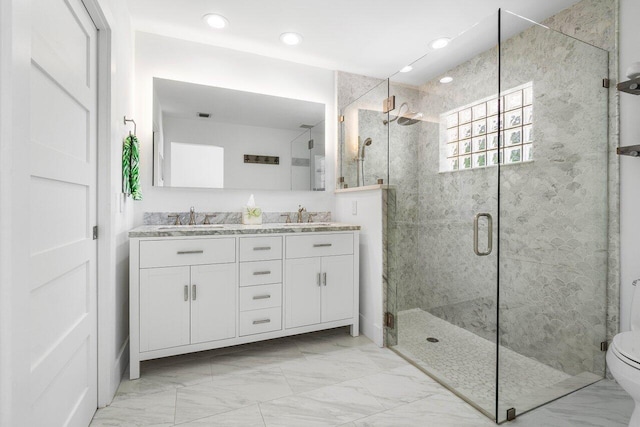 bathroom featuring vanity, a shower with shower door, and toilet