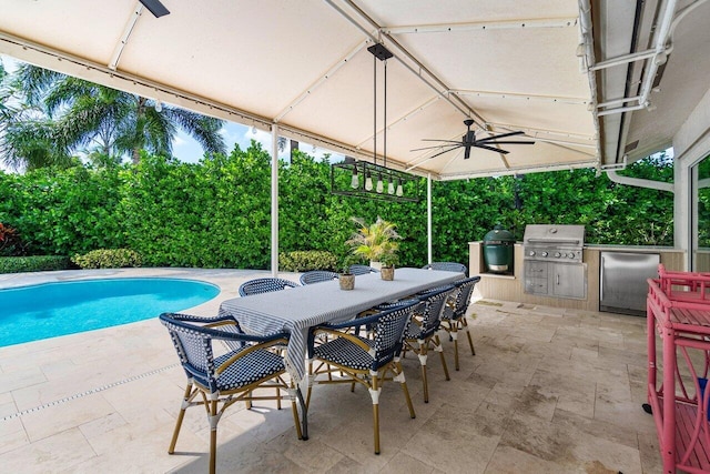 view of swimming pool with a patio, exterior kitchen, an outdoor bar, ceiling fan, and grilling area