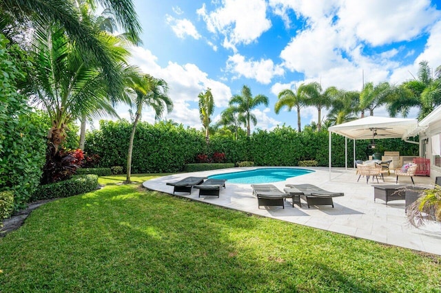 view of pool with ceiling fan, a yard, and a patio area