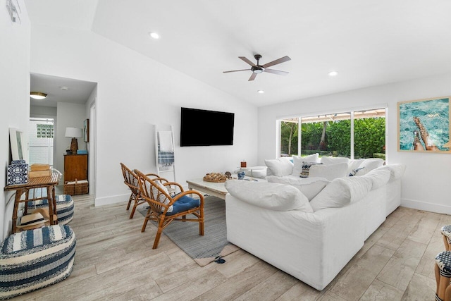 living room featuring vaulted ceiling, light hardwood / wood-style floors, and ceiling fan