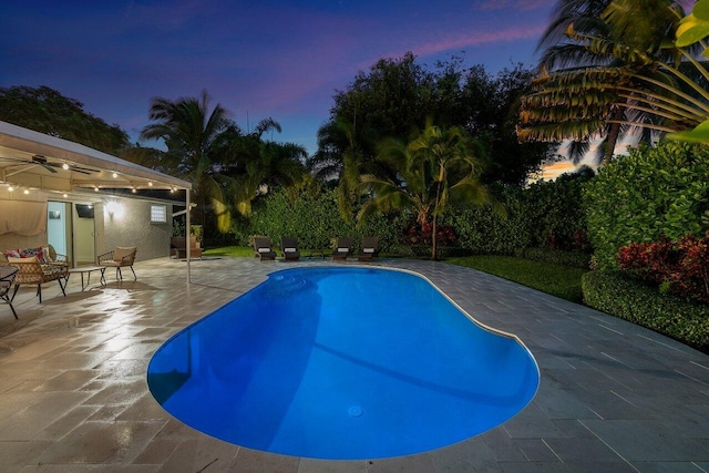 pool at dusk featuring a patio area