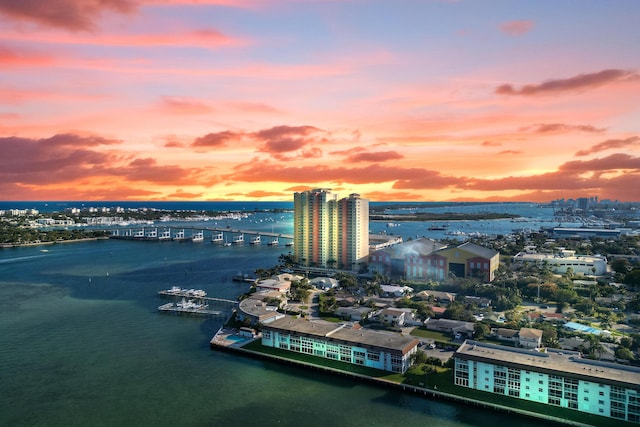 aerial view at dusk featuring a water view